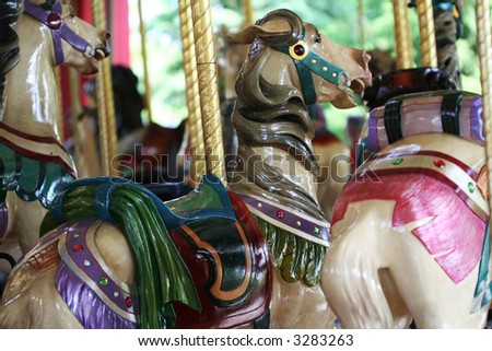 Pretty carousel horses on the merry-go-round at the amusement park