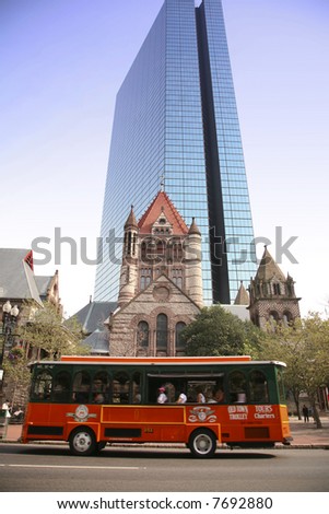 Sightseeing bus passes the Trinity Church and the John Hancock Building in Boston, massachusetts