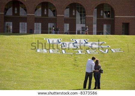 Students admire the UK Believe message painted in the grass