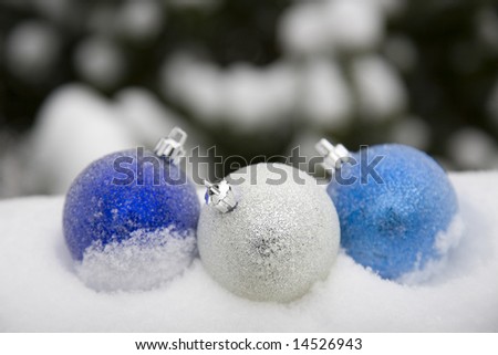 Three blue ornaments in the snow