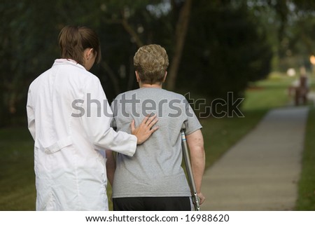 physical therapist helps a woman on crutches