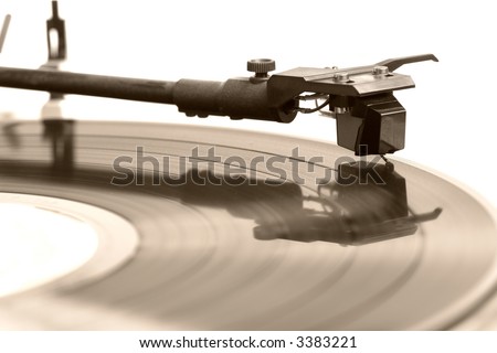 A old vinyl record album plays on a turntable. Sepia tones. Macro, shallow dof, focus on needle. From the 80s.