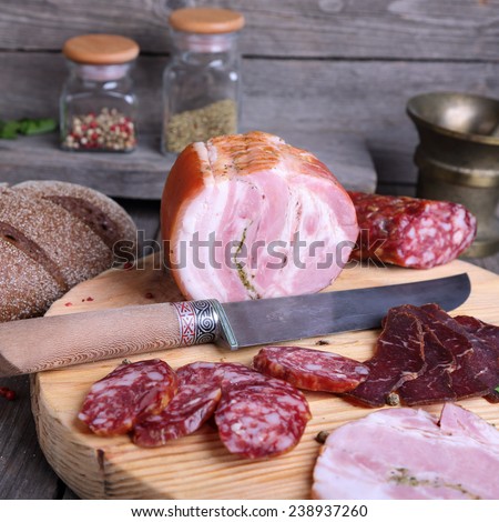 Sliced cold meats on a cutting board, square photo