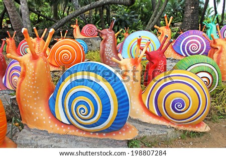 PATTAYA, THAILAND -  JUNE 08, 2014: The synthetic giant snails as garden decoration in Nong Nooch tropical garden in Pattaya, Thailand. More than 2000 visitors daily