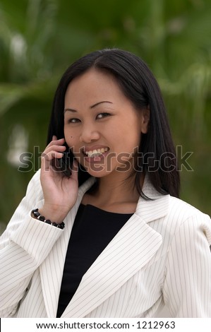 Asian Business Woman with Cell Phone Looking at Camera