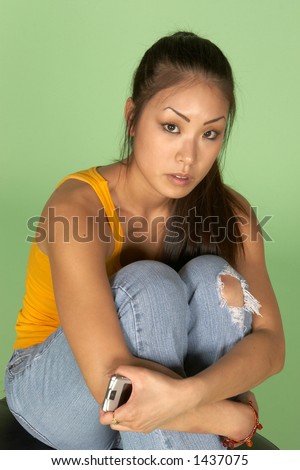 Young Asian Woman Hugging Knees with Cell Phone