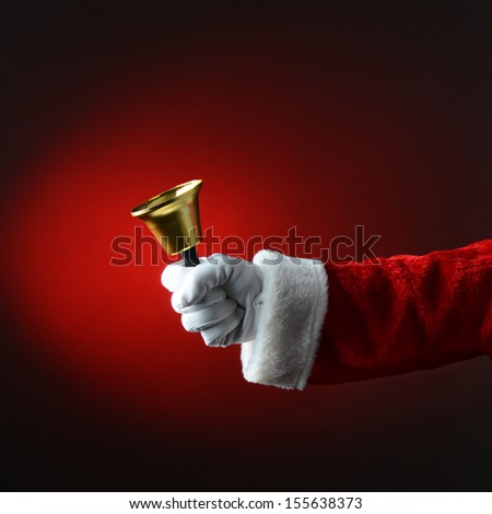 Santa Claus ringing a bell with a red background. Square Format with only Santa\'s hand and arm visible.