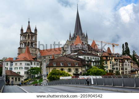 LAUSANNE, SWITZERLAND - JULY 7, 2014: The Cathedral of Notre Dame of Lausanne rises above the city. The Cathedral is currently undergoing renovation and is partially covered with scaffolding.