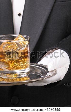 Waiter in tuxedo Presenting Cocktail on silver tray closeup vertical format torso only