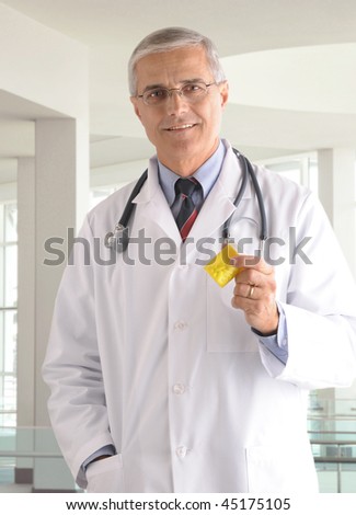 Smiling Middle Aged Doctor holding prescription bottle in modern medical facility vertical format