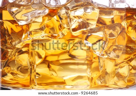 Macro Shot of Whiskey in Glass of Ice isolated over white
