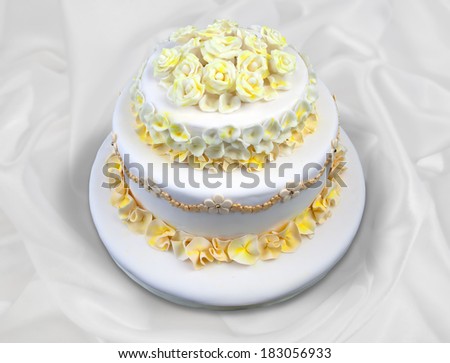Wedding cake with white and yellow flowers isolated on white