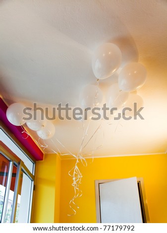 White balloons in yellow and fuchsia room.