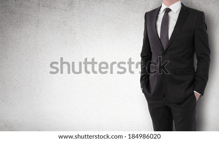 businessman in a suit holds hands in pockets