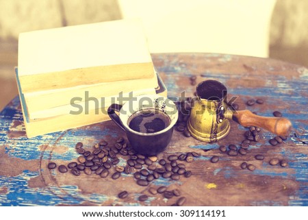 books, coffee beans and a cup on an old table