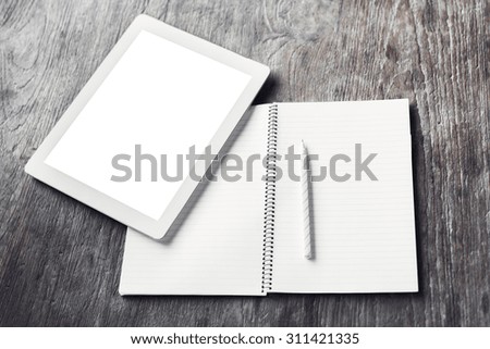 Blank digital tablet with blank diary and pencil on a wooden table, mock up