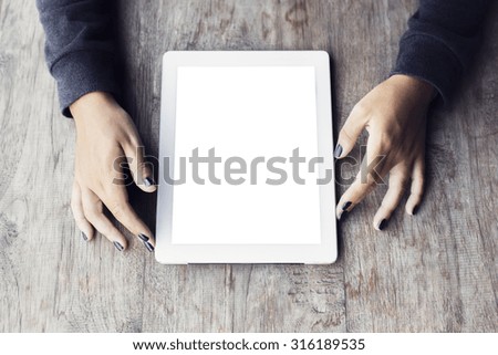 Girl hands with blank digital tablet on a wooden table, mock up