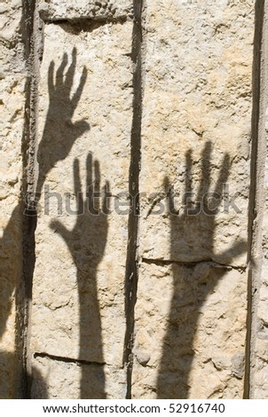 Shadow of humans hand on the stone wall