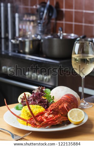 A nice, big plate filled with lobster, rice and a glass of white wine.