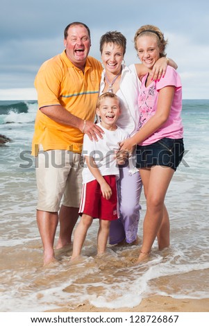 A fun family being photographed on the beach.