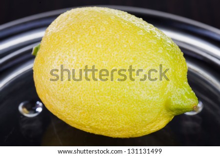 Lemon being photographed on a glass plate.