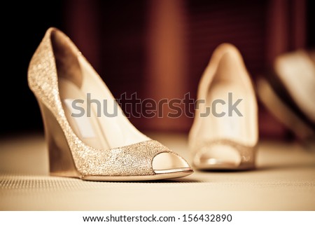 a pair of textured golden shoes on the carpeted floor