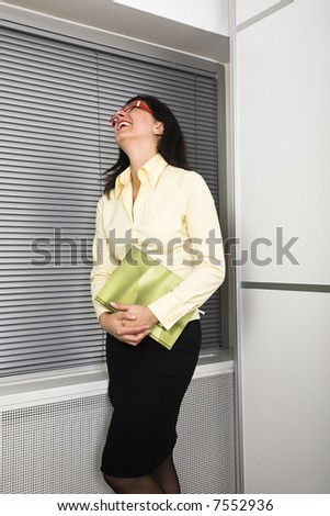Businesswoman laughing out loud holding her office diary.