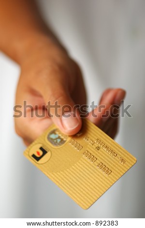 Woman\'s Hand Holding a Gold Credit Card