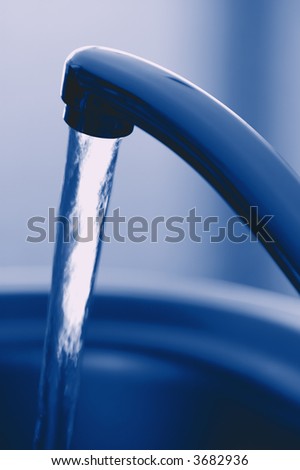 Flowing Fresh Tap Water. Shallow DOF. Focus on Tap.