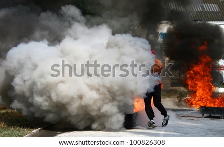 Man in smoke extinguishes fire