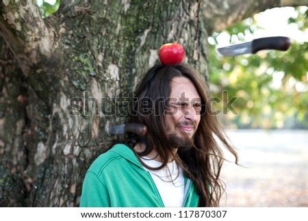 Throwing knife into apple on a guy\'s head