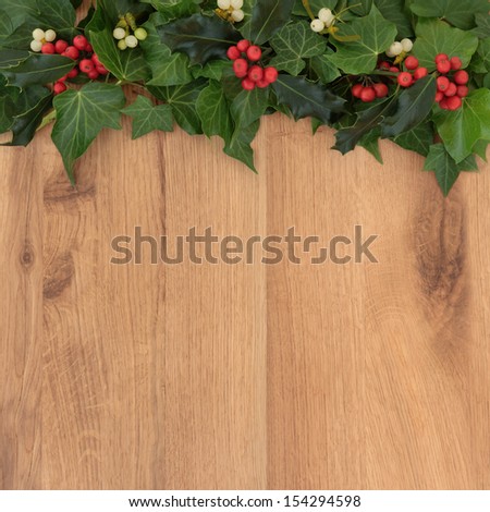 Christmas background border with holly, ivy and mistletoe oak background.