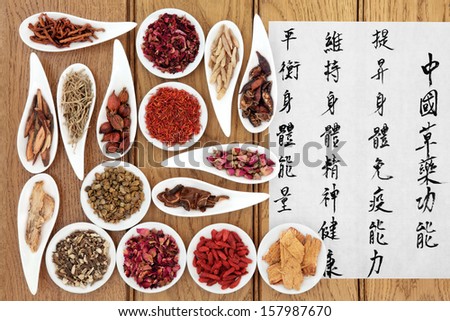 Traditional chinese herbal medicine with mandarin calligraphy on rice paper over oak background. Translation describes the medicinal functions to  maintain body and spirit health and balance energy.