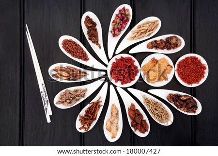 Chinese herbal medicine selection in white china bowls with chopsticks.