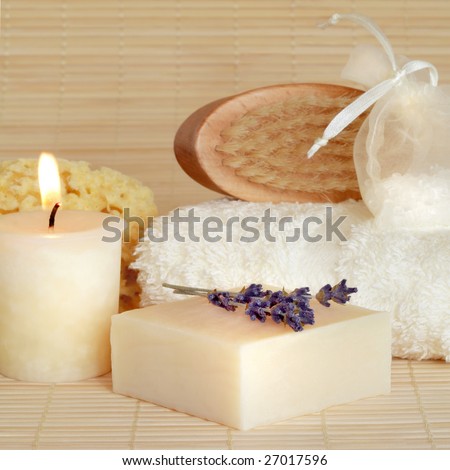 Natural cleansing skincare beauty products with lit by a candle over bamboo background.