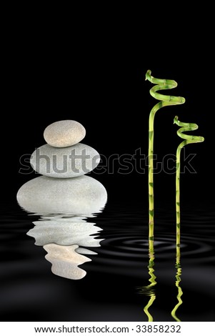 Zen abstract of grey spa stones in perfect balance and lucky bamboo grass with reflection in rippled water, over black background.