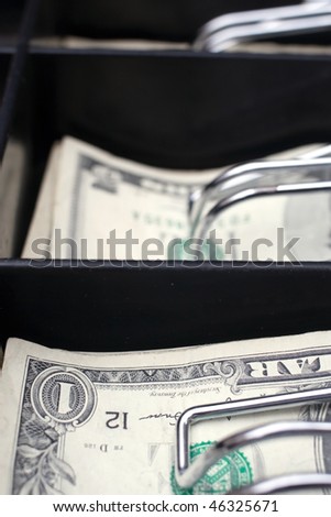register till with one and five dollar bills.  Shot with a short depth of field.