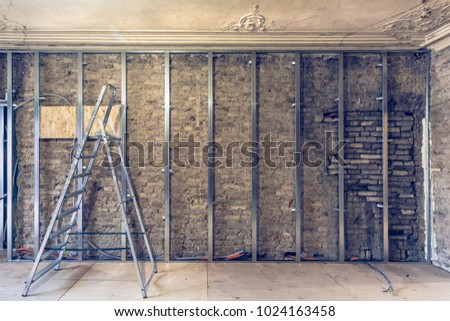 Working process of installing metal frames for plasterboard (drywall)   gypsum walls with ladder and tools in apartment is under construction, remodeling, renovation, extension, restoration   商業照片 © 