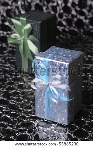 Two gift boxes on black-silver background with selective focus