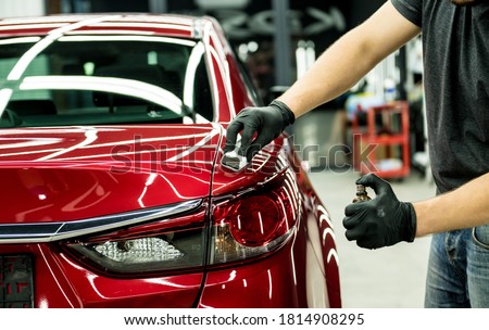 Car service worker applying nano coating on a car detail. Сток-фото © 