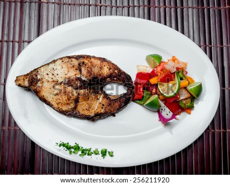 Roasted fish on the white plate. Barbecue. Restaurant