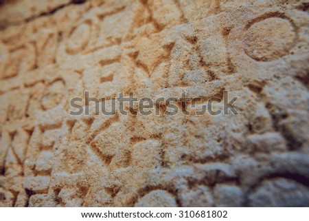 Ancient letters carved on a stone wall. Background