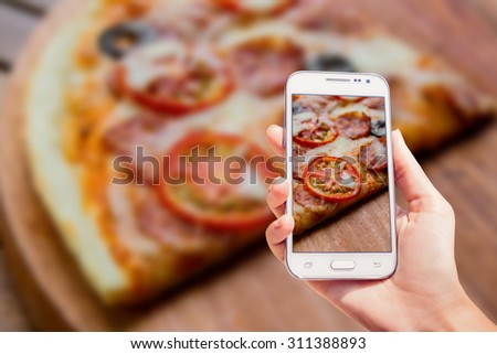 Large pizza on the screen. Phone in the hand. Restaurant