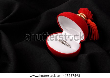 Ring and ear rings in red box on black background