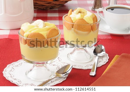 Two dessert cups of vanilla pudding and cookies