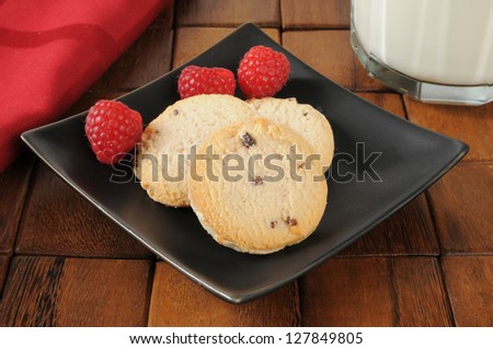 Closeup of shortbread cookies with raspberries and milk