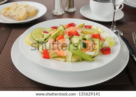 A bowl of shrimp and avocado salad with coffee