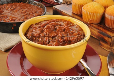 a bowl of chili con carne with cornbread muffins