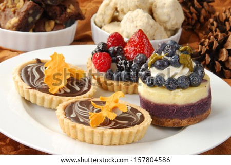 a plate of holiday dessert tarts with cookies and brownies