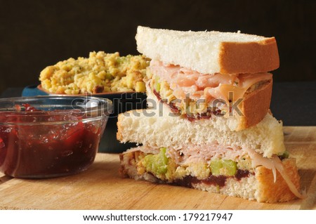 A turkey sandwich with stuffing and cranberry sauce